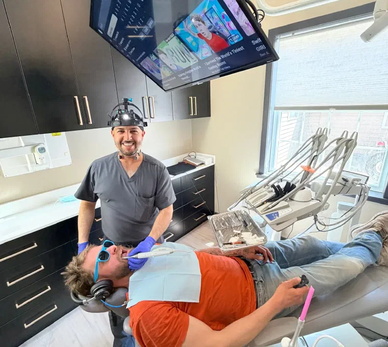 Cookstown dentist caring for a patient wearing headphones and enjoying in-room entertainment