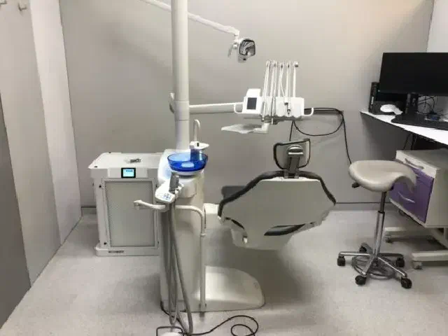Dental professional working beside a clinic air-purification unit